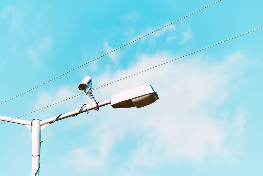 closeup photo of white lamp post and camera, white CCTV camera on lamp post during daytime