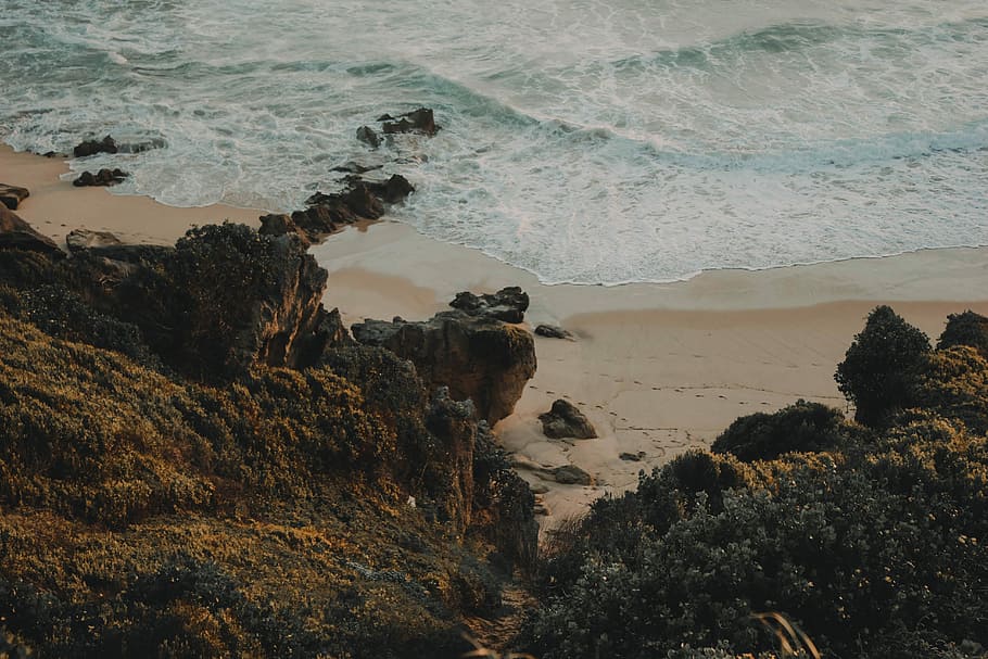 top view photo of rocky cliff near body of water, black, brown HD wallpaper