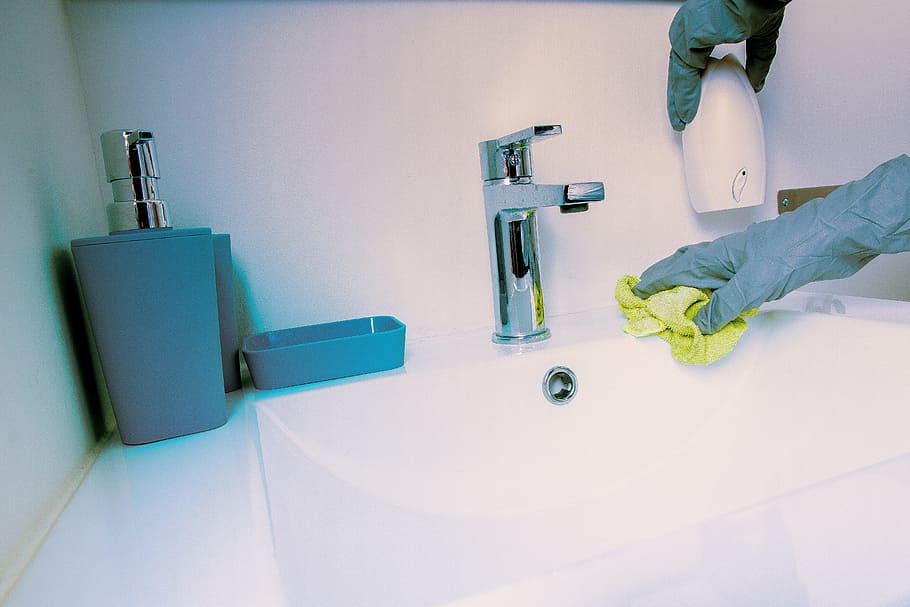 photo of person wearing gray gloves near faucet, cleanliness