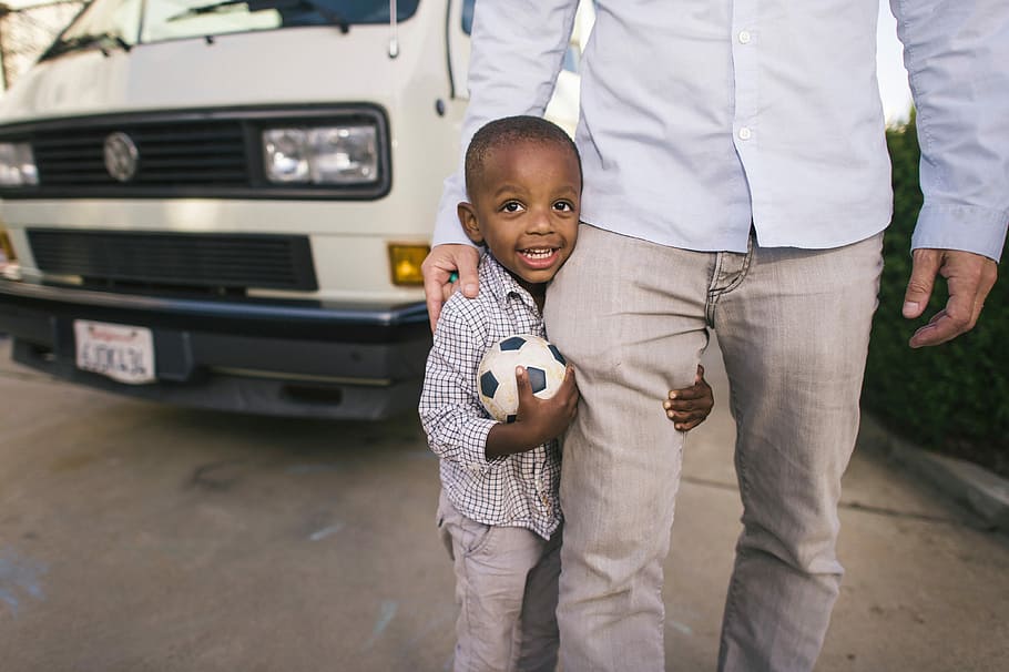 boy standing beside man in white dress shirr near vehicle, boy hug on man HD wallpaper