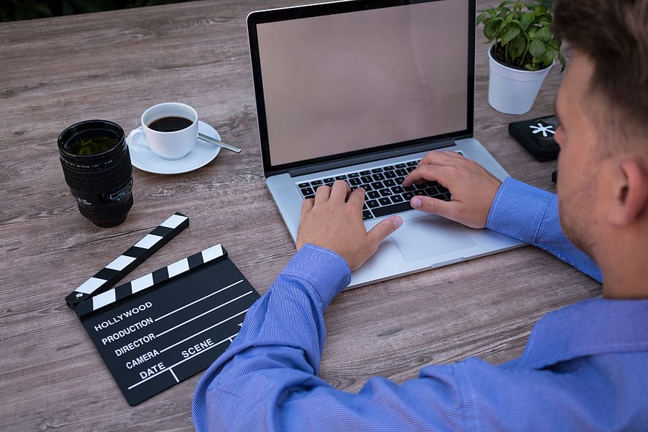 person sitting beside table while using laptop, filmmaker, on the laptop HD wallpaper