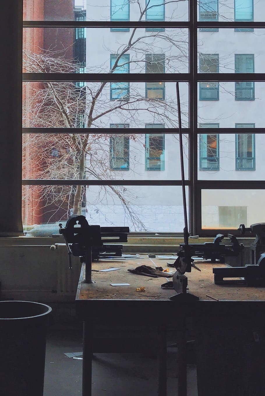 view of white building from glass window, black clamp vise on wooden table beside window HD wallpaper