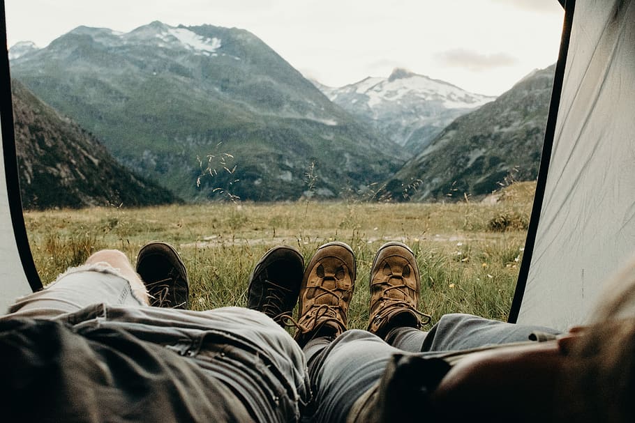 two person lying on tent, two person lying inside tent facing mountain HD wallpaper