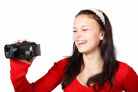 woman smiling while holding video camera, camcorder, digital HD wallpaper