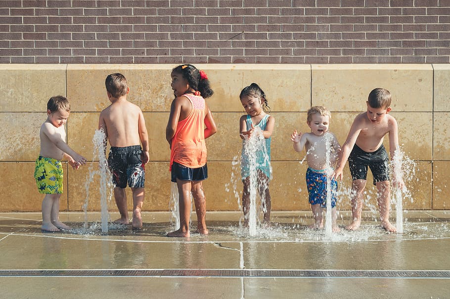 five children playing water during day time, children playing near fountain outdoor during daytime HD wallpaper