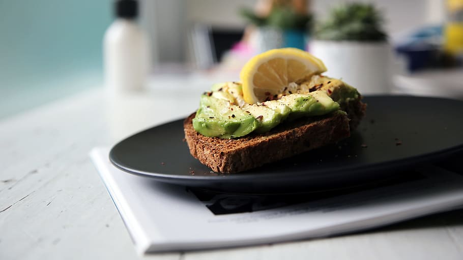 brown bread with sliced avocado and lemon on top, slice of lemon on black plate, HD wallpaper