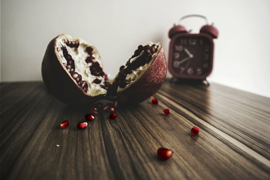 pomegranate fruit on wooden table near bell alarm clock, pulp HD wallpaper