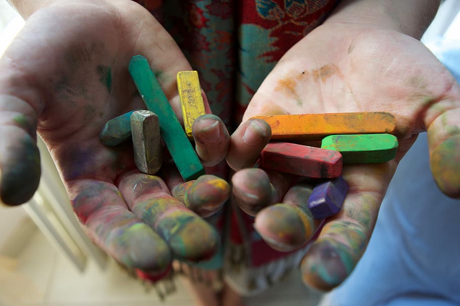 person holding assorted-color chalks, selective focus photography of person's painted palm with crayons on top HD wallpaper