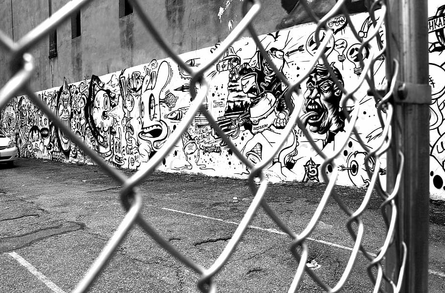 grayscale photo of chain link wire, graffiti, wire mesh fence