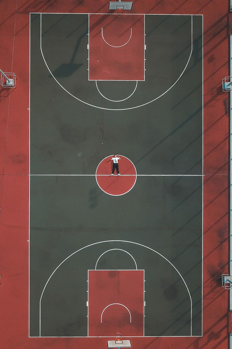 shots from the court, man lying in the middle of basketball court