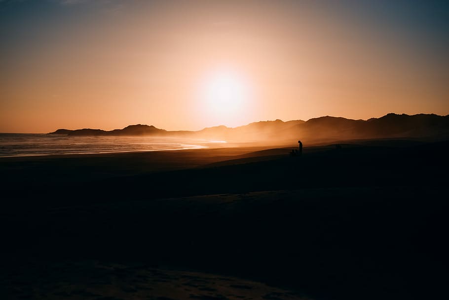 silhouette photo of seashore during dawn, silhouette of man standing near sea during sunset HD wallpaper