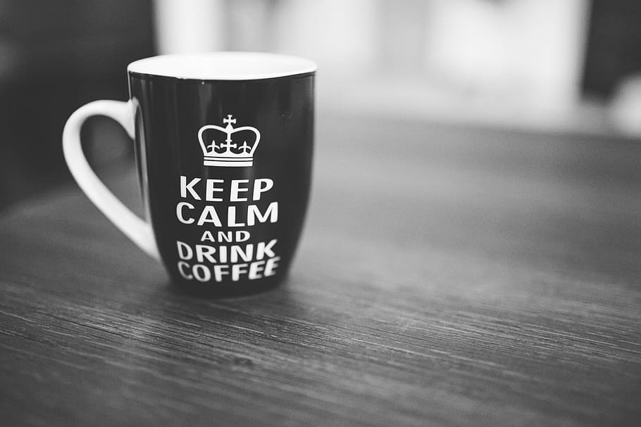black and white ceramic mug with keep calm and drink coffee print on gray surface