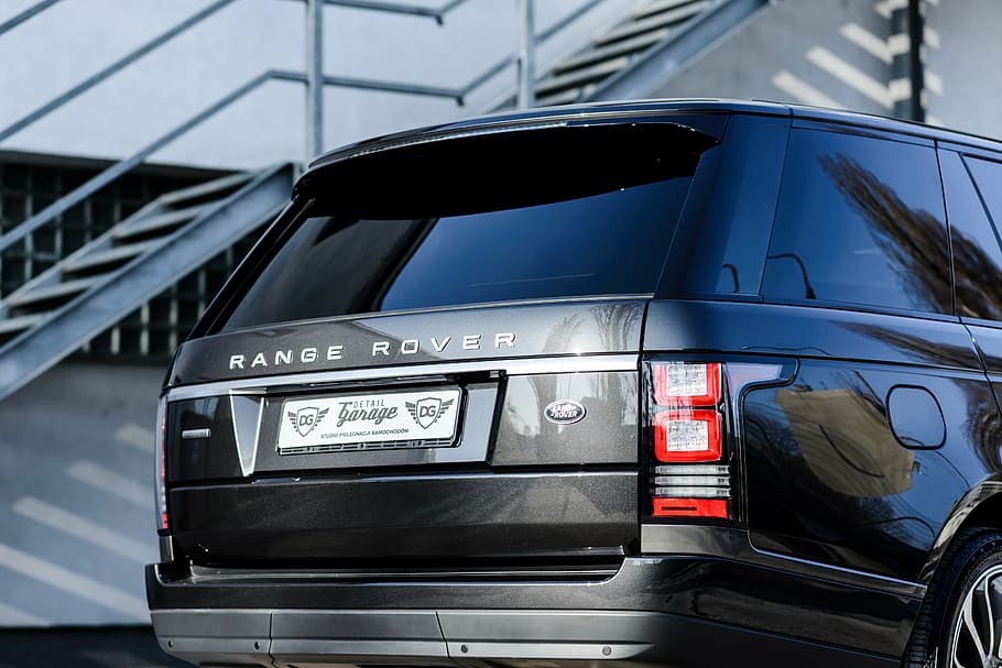black Land Rover Range Rover SUV parked near gray metal stair case