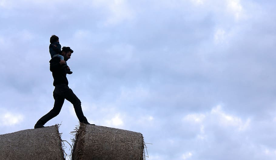 man carrying child under cloudy sky during daytime, hay, stack HD wallpaper