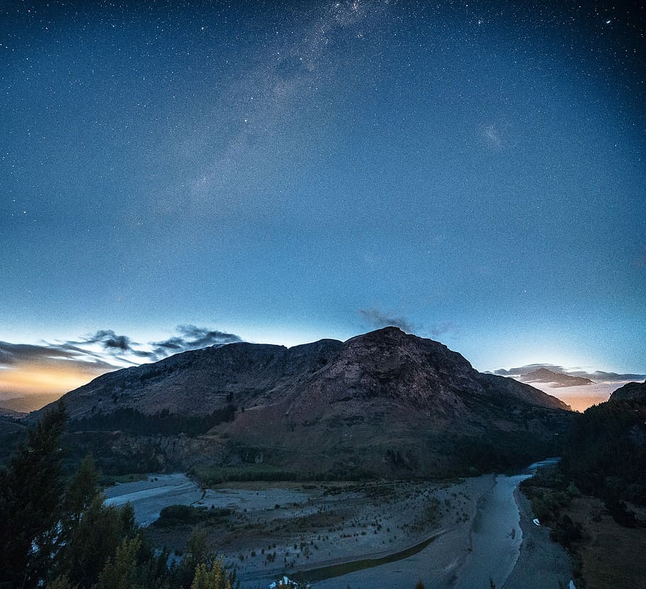 photo of mountain during night time, rocky mountain under blue skies HD wallpaper