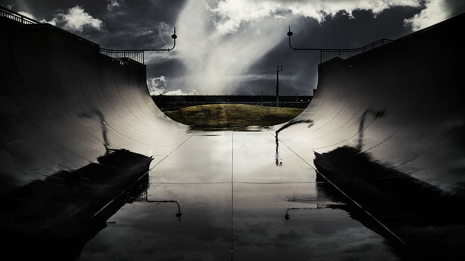 greyscale photography of skateboard stadium ramp near field under cloudy skies HD wallpaper