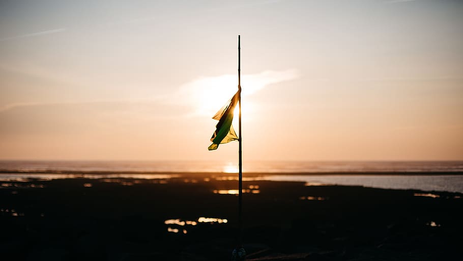 flag half mast near body of water during golden hour, flag on pole during sunset HD wallpaper