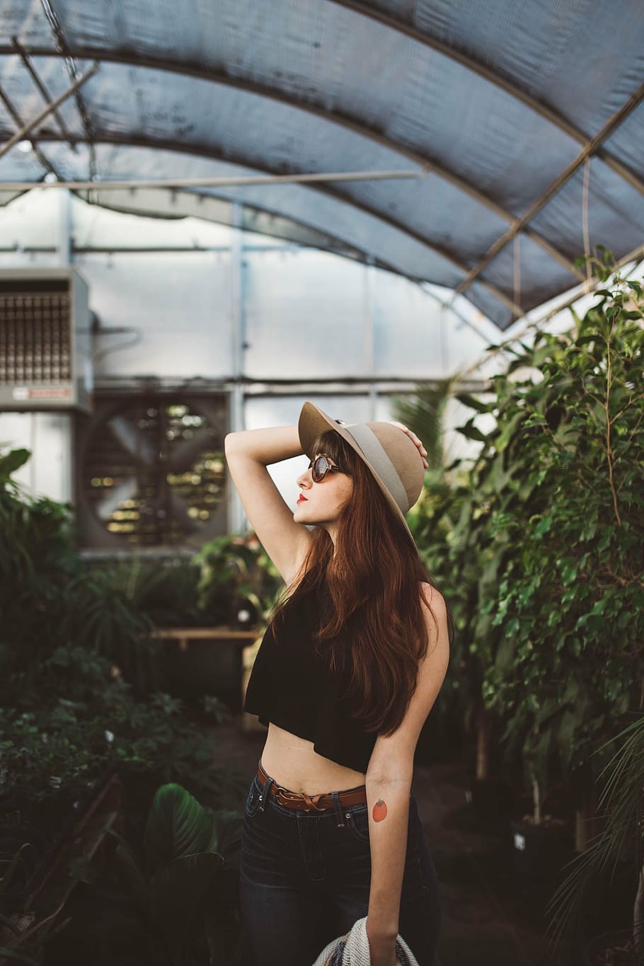 woman wearing crop top surrounded by plants, girls, hat, stomach
