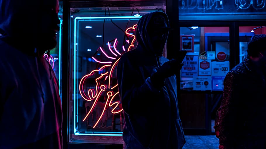 man standing holding smartphone, silhouette of person wearing hoodie HD wallpaper