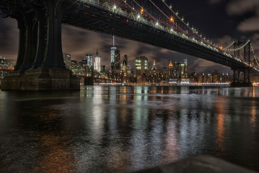 low light photography of New York buildings, bridge with lights near city