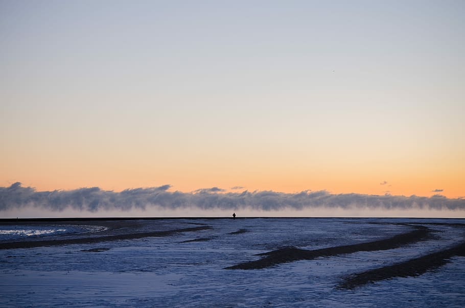 open file with gray sky, person standing on plain covered with snow HD wallpaper