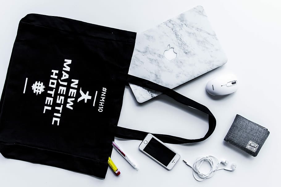 flat lay photography of tote bag beside iPhone and wallet, photo of gadgets and bag