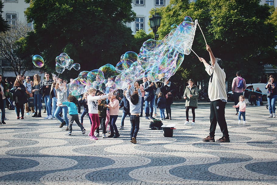 group of people playing bubble at park, man making water bubbles near children playing during day HD wallpaper