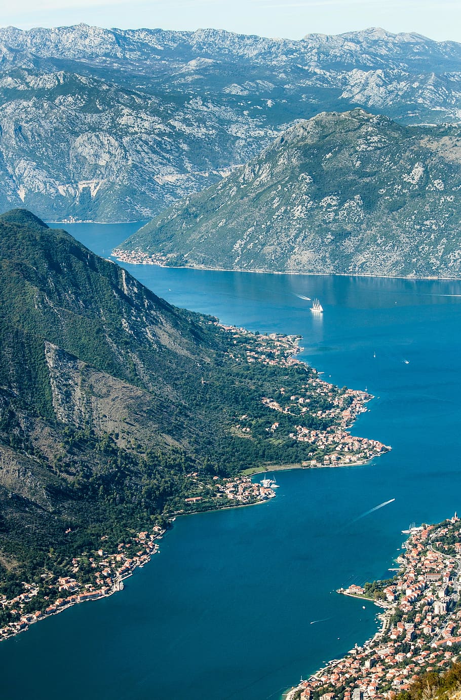aerial photo of green mountain beside body of water at daytime HD wallpaper