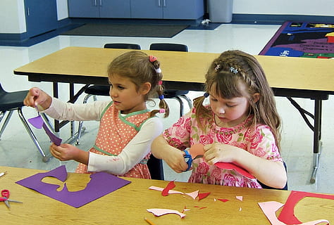 two girls cutting purple papers in front of brown table, classroom HD wallpaper