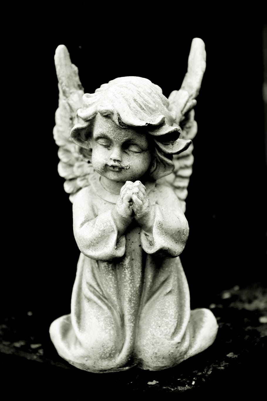 cherub praying figurine on top of black surface, angel, stone angel