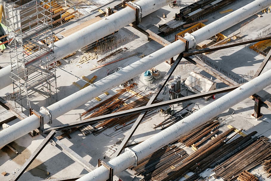 building under construction during daytime, aerial photo of metal pipes