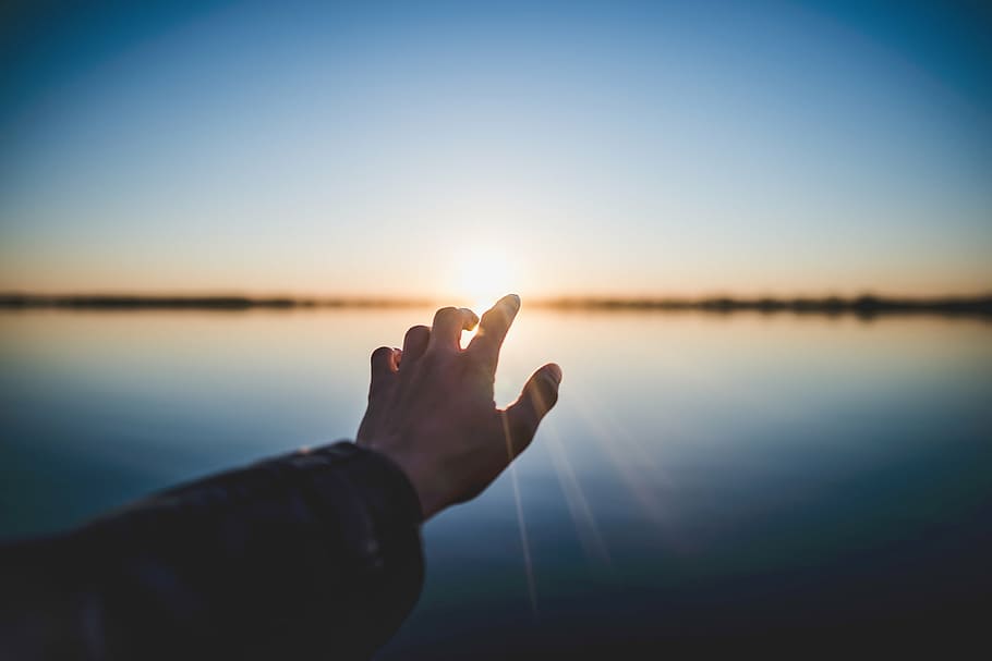 selective focus photography of person reaching to sun light rays HD wallpaper
