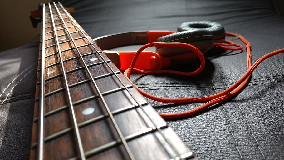 closeup photography of 4-string guitar over headset, Headphones
