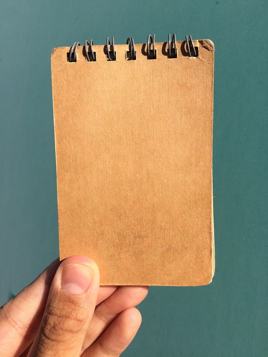 brown spring notebook, left hand, on the cover, male, flesh color