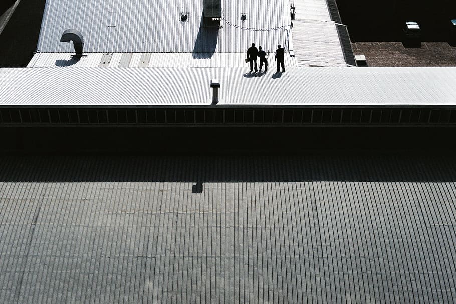 three men standing on gray pavement, three person on gray galvanized iron sheet during day time HD wallpaper