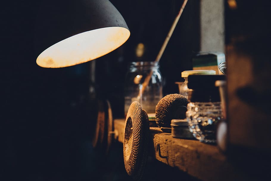 turned-on table lamp near of glass bottle, workshop, mechanical HD wallpaper