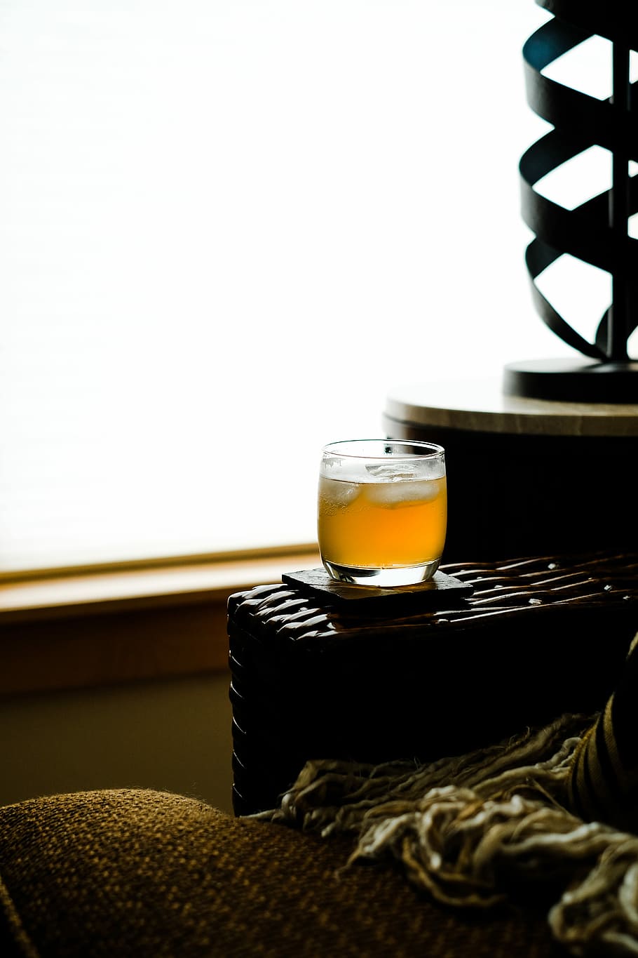 clear shot glass filled with yellow liquid with ice on brown rack HD wallpaper