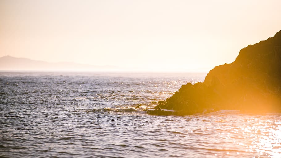 photo of island near body of water, body of water near the cliff golden hour HD wallpaper