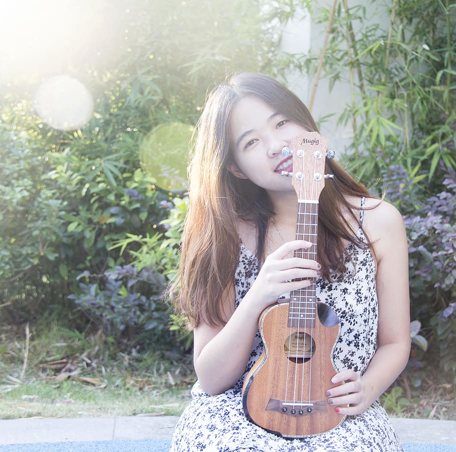 sweet, woman holding ukulele standing near plant, guitar, instrument