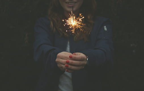 woman wearing blue jacket holding stick sparkle, girl holding sprinkle fireworks HD wallpaper