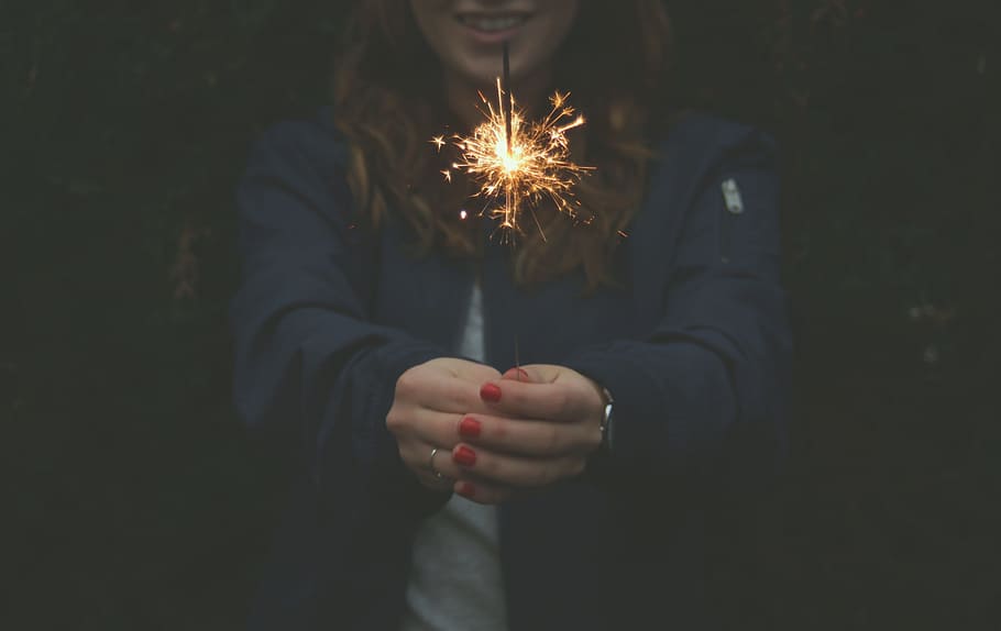woman wearing blue jacket holding stick sparkle, girl holding sprinkle fireworks HD wallpaper