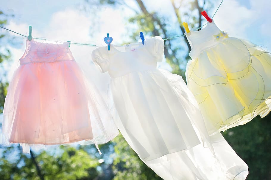 girl's three pink, white, and yellow sleeveless dress, clothesline
