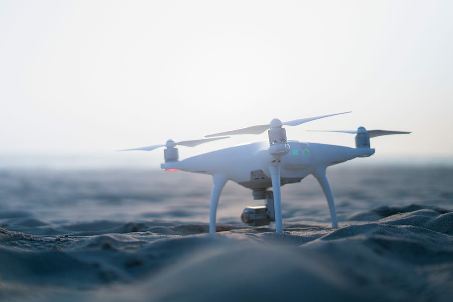 white DJI Phantom drone on sand, white drone on sand in macro photography HD wallpaper