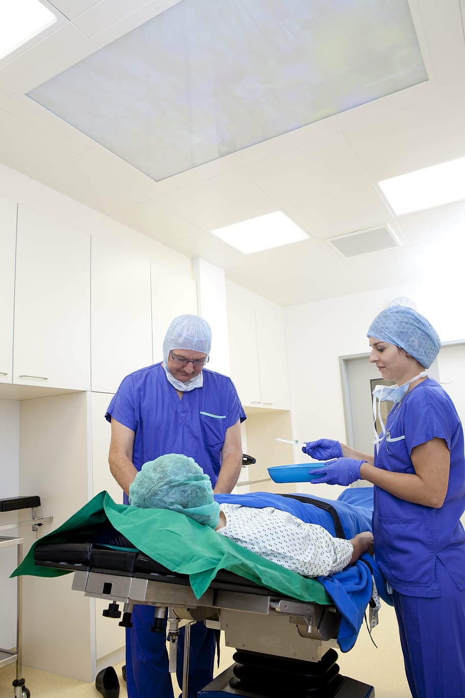 man and woman wearing blue scrub top with pants, operation, doctor