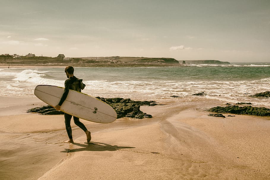 A surfer walks along the beach on the coast of Cornwall, England. Image captured with a Canon 5D DSLR, HD wallpaper
