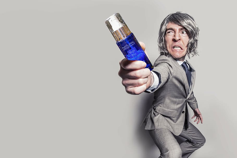 man in gray label suit jacket holding blue fragrance bottle, adult
