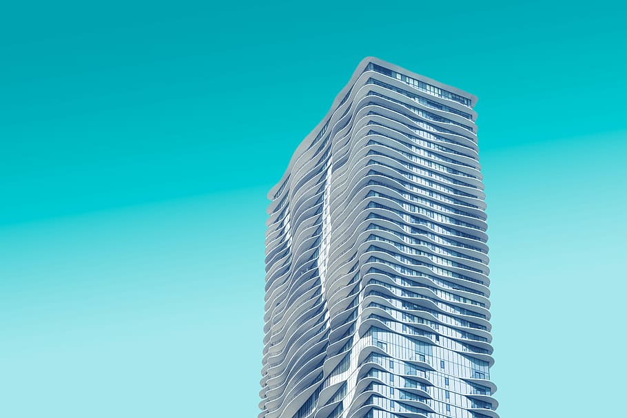 gray high rise building with teal background, gray concrete building under blue sky during daytime photography