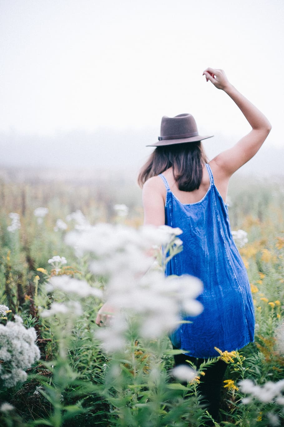 woman walking a flower field, woman walking along flower field while rising her right hand HD wallpaper
