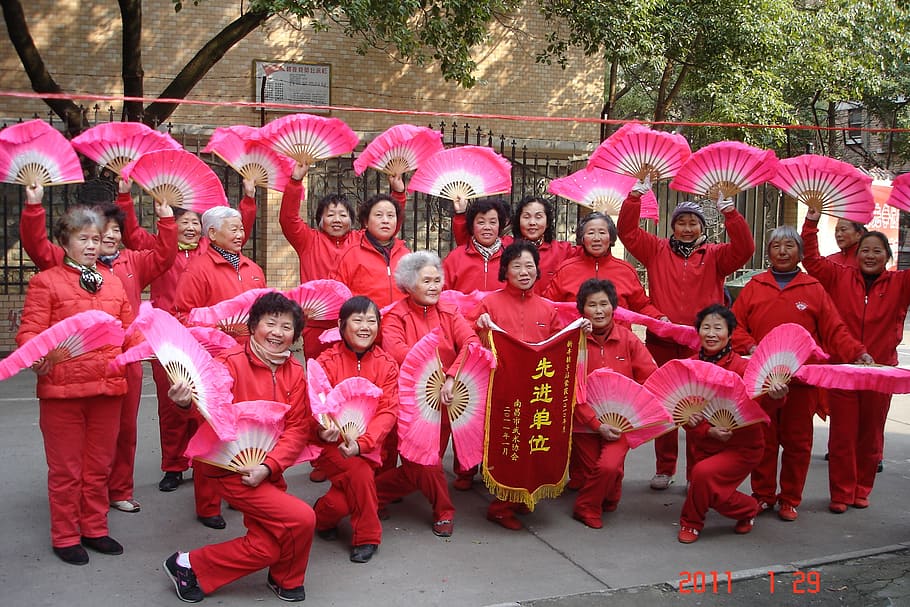 group of people wearing red traditional costume holding hand fan HD wallpaper