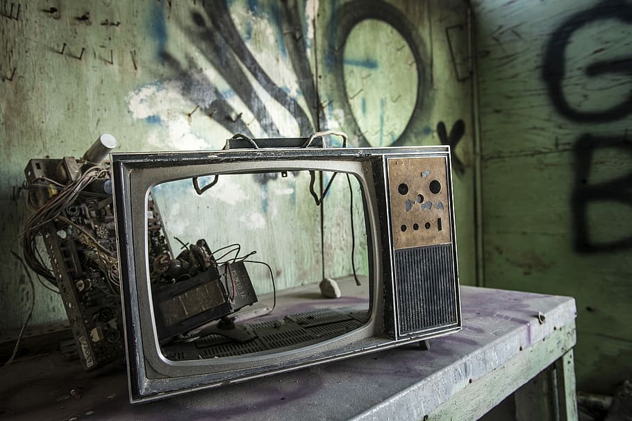 vintage TV on gray wooden table inside room, vintage gray TV frame